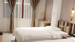 A hotel room with two beds, a desk, a chair, and a hanging light fixture. - Wenchang Haiju Diary Homestay (Wenchang)