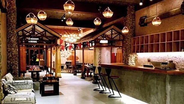 A hotel lobby with a bar area, seating arrangements, and hanging lights. - Wenchang Haiju Diary Homestay (Wenchang)