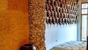 A room with a stone wall, a large vase, and a patterned floor. - Wenchang Haiju Diary Homestay (Wenchang)