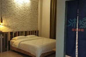 A room with a brick-patterned wall, a wooden bed, and a curtain with text. - Wenchang Haiju Diary Homestay (Wenchang)