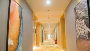 A long, narrow hallway with a patterned carpet and artwork on the walls. - Wanhou Academy of Fine Arts Hotel (Yiyang Xiufeng Park Branch) (Yiyang)