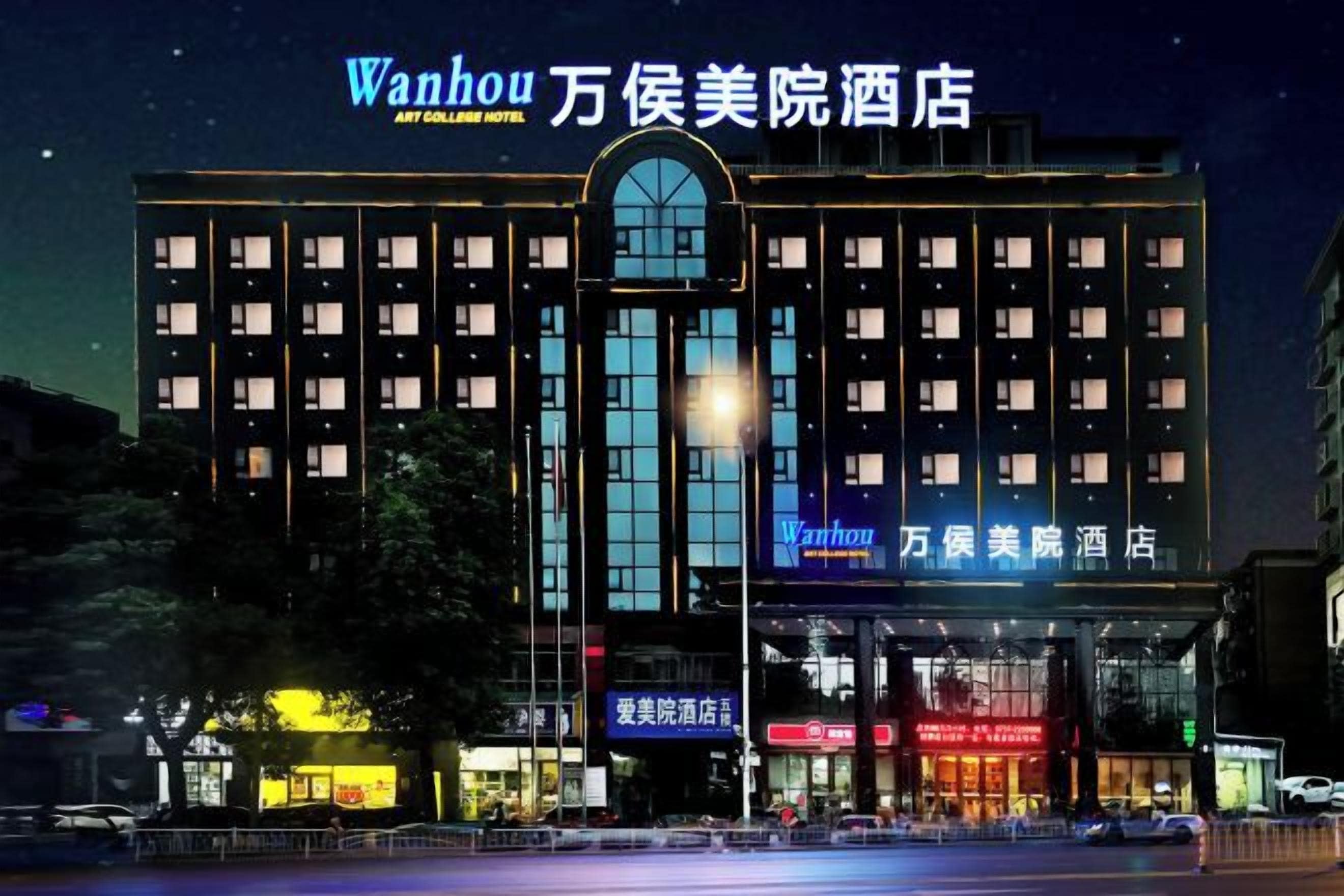 A hotel with multiple floors, a prominent entrance, and illuminated signage.