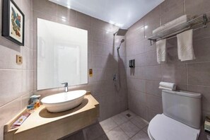 A modern bathroom with a large mirror, a sink, a toilet, and a shower. - Sinage Tianyuan Hotel (Mianyang)