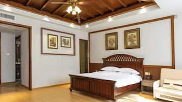 Un dormitorio con una cama de madera, una mesita de noche, una silla y cuadros en las paredes.
