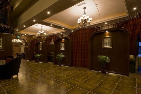 A spacious lobby with a tiled floor, a grand chandelier, and wooden paneling. - Sinage Tianyuan Hotel (Mianyang)