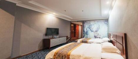 A hotel room with two beds, a television, a desk, and a painting on the wall.