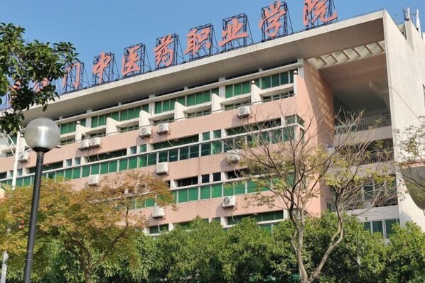 A multi-story building with a sign indicating it is a medical facility. - Huaxuan Hotel (Jiangmen)