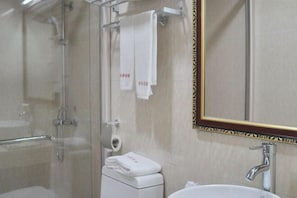 A modern bathroom with a glass-enclosed shower, a white sink, and a large mirror with a decorative frame. - Huaxuan Hotel (Jiangmen)