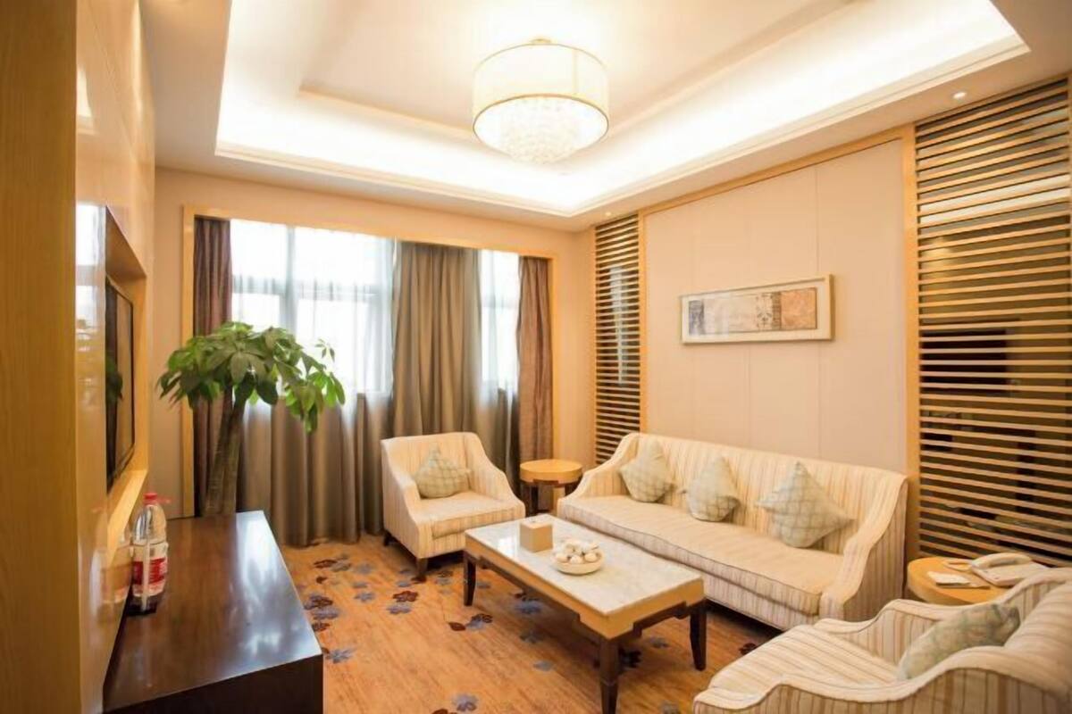 Un salon avec un canapé, des fauteuils, une table basse et un téléviseur.