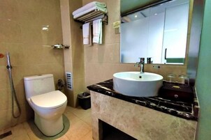 Un baño con inodoro, lavamanos y espejo.