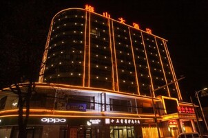 Un hotel de varios pisos con señalización iluminada y un llamativo logotipo de 'oppo' en la planta baja.