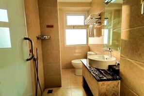 A bathroom with a shower, toilet, and sink.