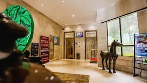 A lobby with a reception desk, a large window, and a statue of a horse. - Nanhai Hotel (Zhanjiang)
