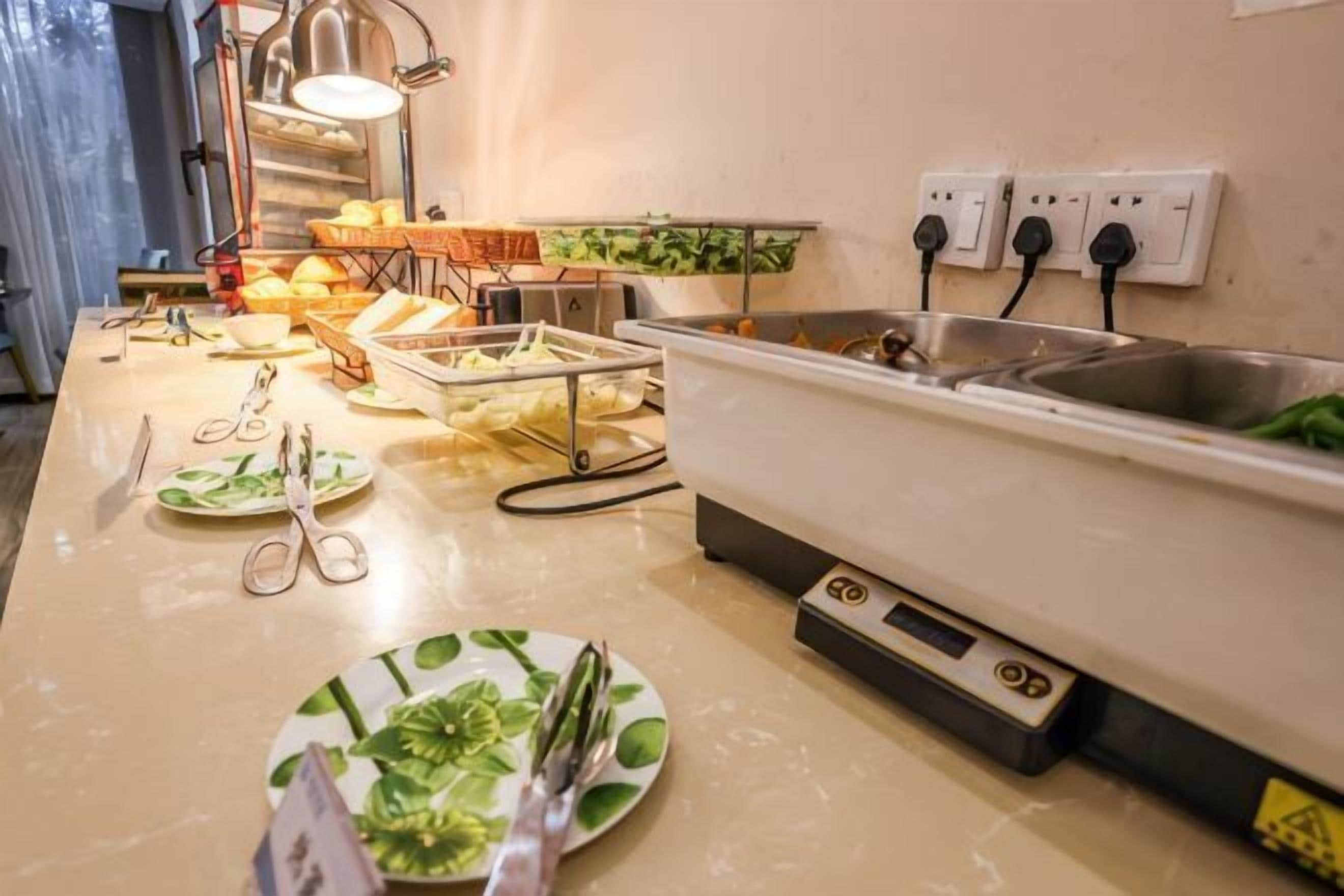 A kitchen area with a sink, countertop, and various utensils.