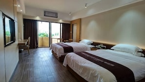 A hotel room with two beds, a desk, and a balcony. - Nanhai Hotel (Zhanjiang)