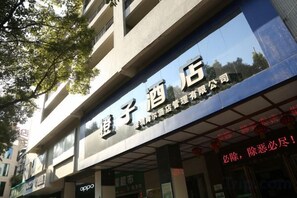 A hotel with a prominent sign, multiple floors, and a visible entrance. - Orange Hotel (Chenzhou)