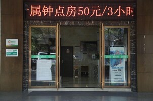 A hotel entrance with a glass door and a sign indicating a price of 50 yuan per night.