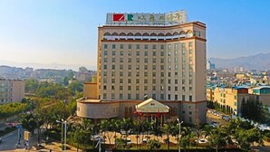 A tall hotel with a prominent sign on the top. - L. Road Grand Hotel (Lincang)