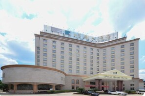 A large hotel with a prominent entrance and a curved building section to the left. - L. Road Grand Hotel (Lincang)