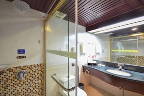 A bathroom with a glass partition, a sink, and a toilet.