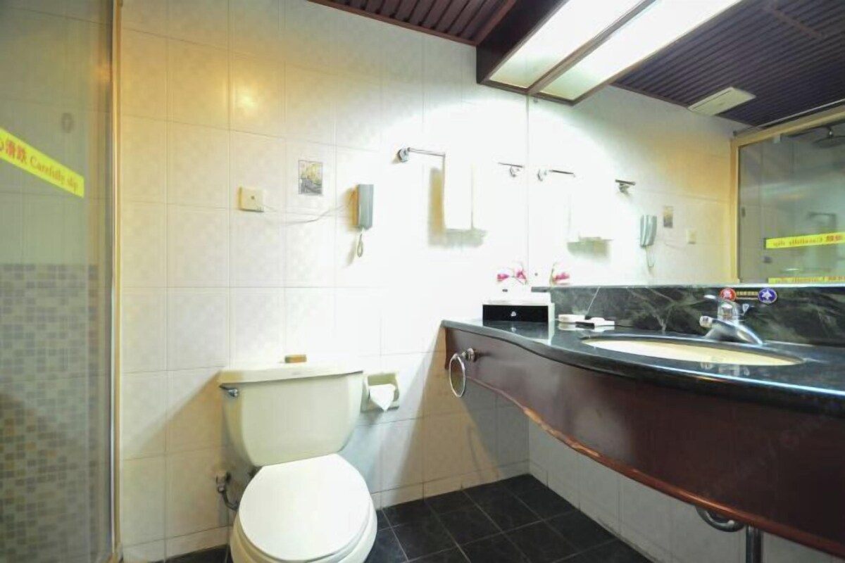 Un baño pequeño con inodoro, lavamanos y espejo.