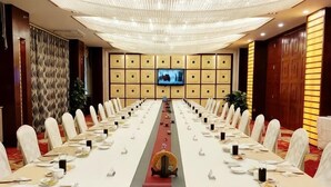 A conference room with a long table, chairs, and a television screen. - L. Road Grand Hotel (Lincang)