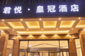 A hotel entrance with illuminated signage. - Crown Hotel Junyue (Fuzhou)