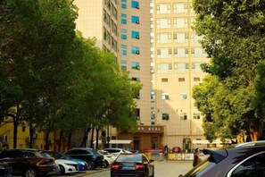 A multi-story building with a parking lot in front.