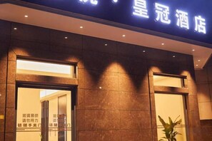 The exterior of a hotel with a sign above the entrance.