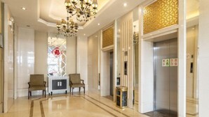 A hotel lobby with a chandelier, two armchairs, a reception desk, and an elevator. - Changtai Palace Hotel (Hanggin Banner)