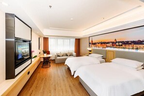 A hotel room with a cityscape view, a flat-screen TV, a sofa, a dining table, and two beds. - Vienna International Hotel (Yangzhou)