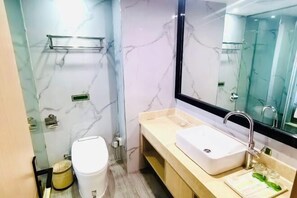 A modern bathroom with a marble wall, a white sink, and a glass shower enclosure. - Vienna International Hotel (He Yuan Store, Outlets Plaza, Yangzhou) (Yangzhou)