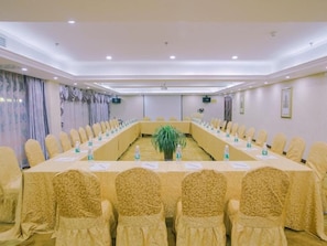 A conference room with a long table, chairs, and nameplates. - Vienna International Hotel (Yangzhou)
