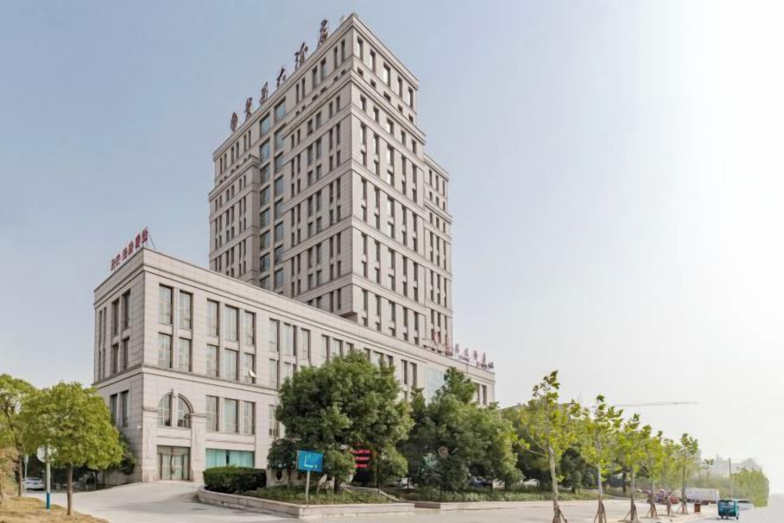Un edificio de varios pisos con fachada simétrica, ventanas amplias y techo plano.