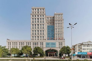 Un edificio de varios pisos con una entrada central y un amplio frente de vidrio.