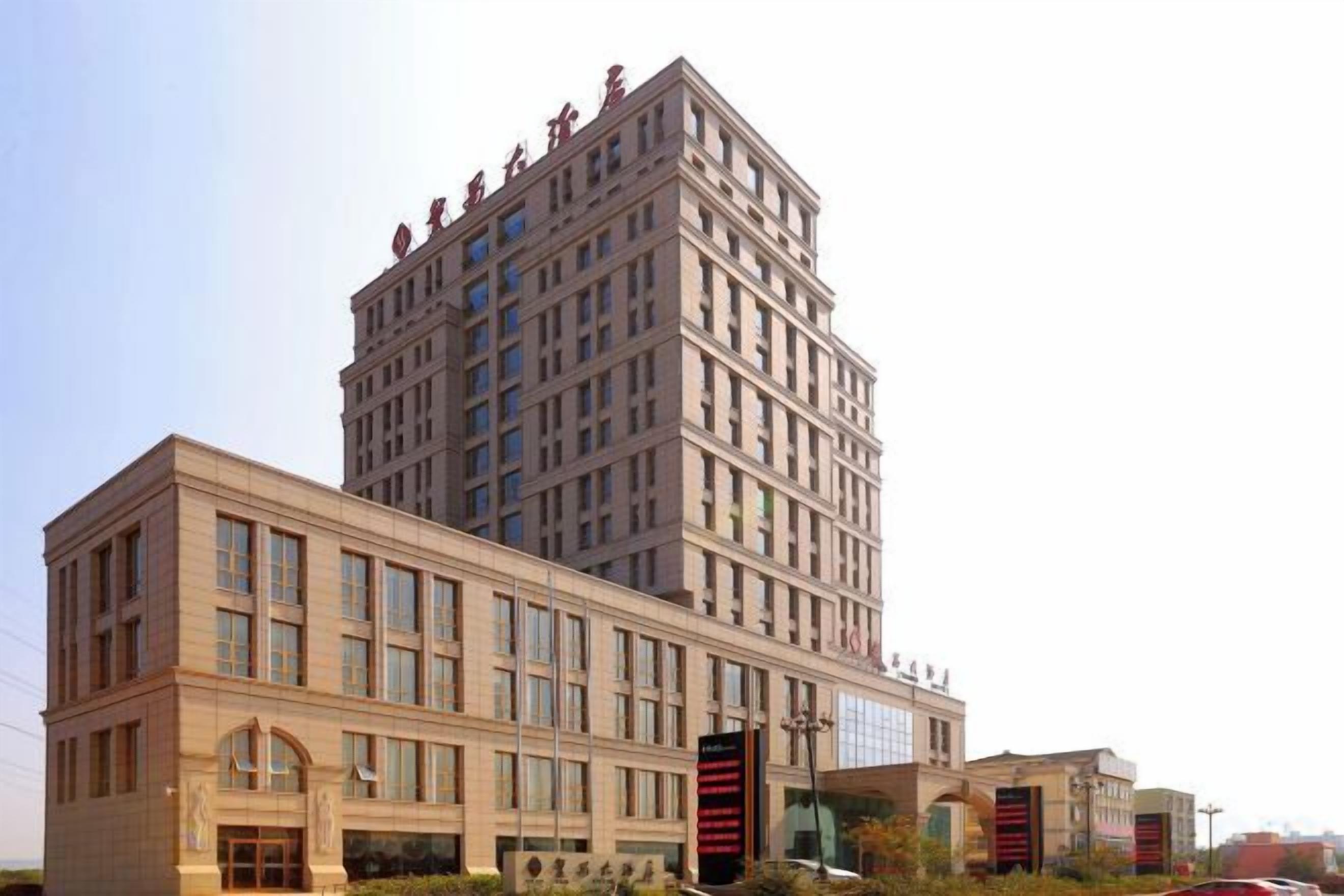 A multi-story building with a prominent corner entrance and large windows.
