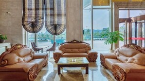 A lobby with leather sofas, a coffee table, and large windows. - Fan Chang Hotel (Wuhu)