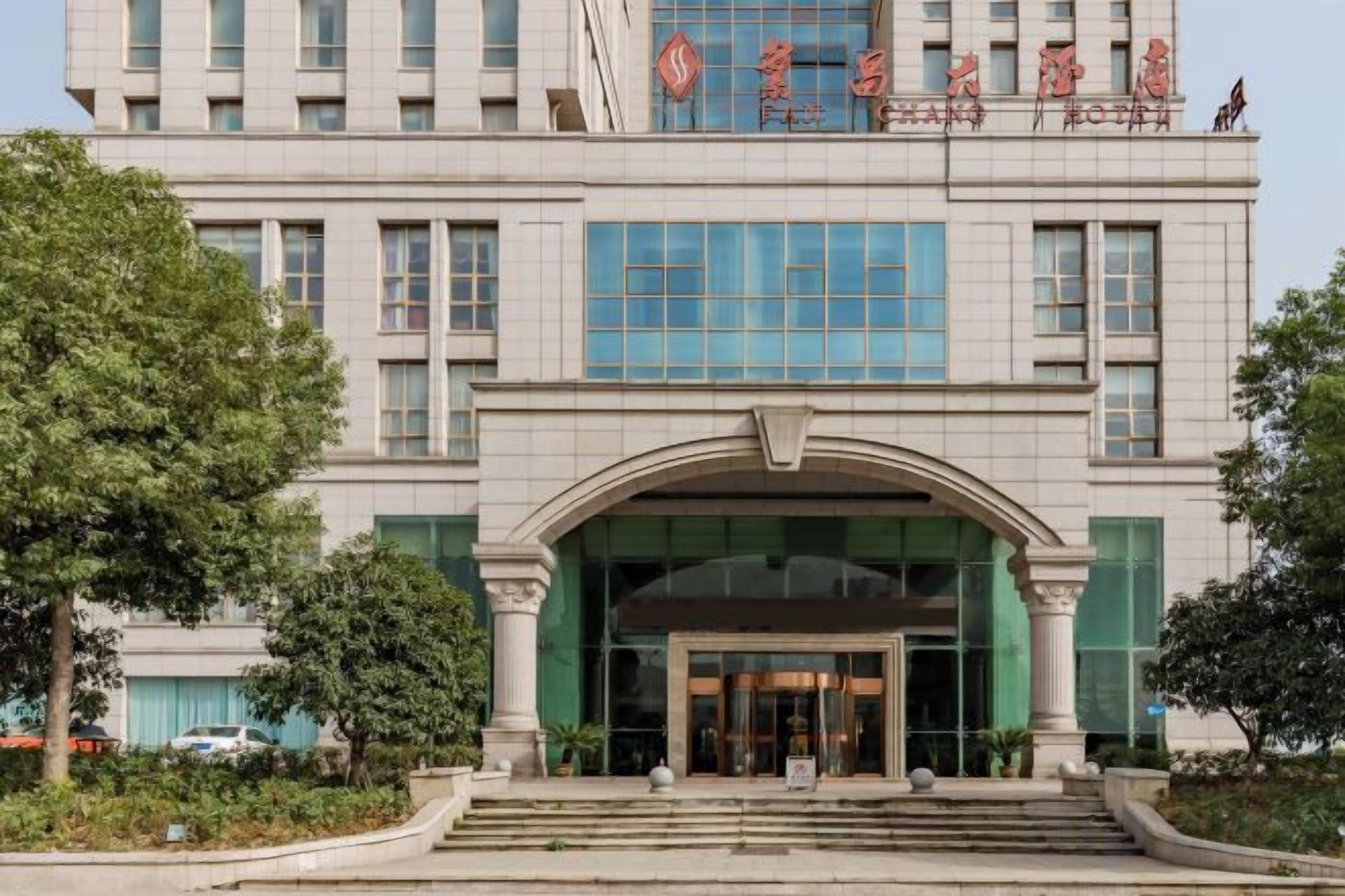A multi-story building with a prominent entrance, large windows, and a sign with Chinese characters.
