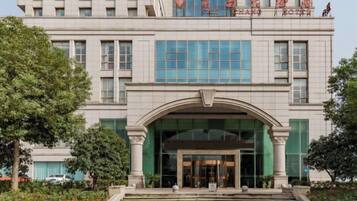A multi-story building with a prominent entrance, large windows, and a sign with Chinese characters.