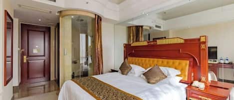 Une chambre d’hôtel avec un grand lit, une tête de lit en bois, une table de chevet avec un téléphone et un miroir.