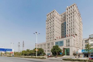 A multi-story building with a modern architectural design, featuring a prominent entrance and a large glass facade. - Fan Chang Hotel (Wuhu)