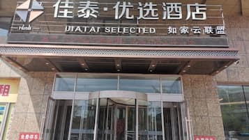A hotel entrance with a glass door and a sign above it.