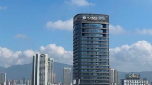 Un moderno edificio de hotel con fachada curva y varios balcones.