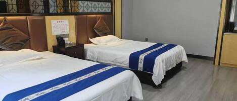 A hotel room with two beds, a nightstand, and a decorative headboard.