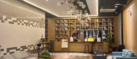 A modern interior with a seating area, a bookshelf, and a bar counter.