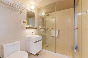 A modern bathroom with a glass-enclosed shower, a white sink, and a toilet. - City Garden Hotel Chain (Chizhou Vocational College Xiushanmen Millennium Ancient City Building ) (Chizhou)
