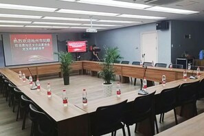 A conference room with a long table, chairs, a projector screen, and a television. - City Garden Hotel Chain (Chizhou Vocational College Xiushanmen Millennium Ancient City Building ) (Chizhou)