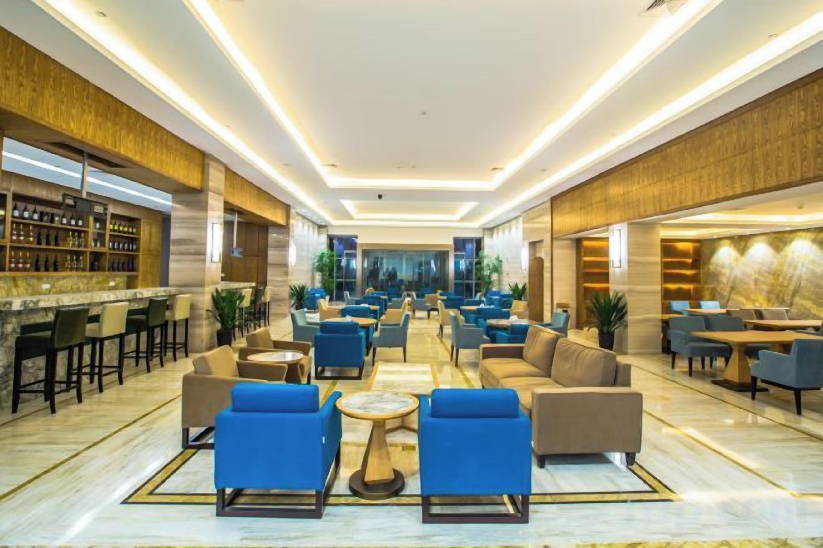 A spacious lobby with a bar area, seating arrangements, and a view towards the back.