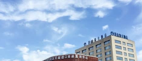 A building with a curved facade and a flat-roofed structure with a sign on top.