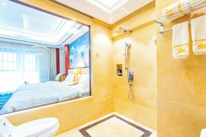 Ein Hotelbad mit großem Fenster, Dusche und Toilette.